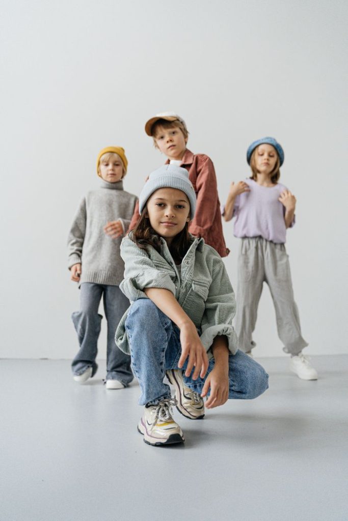 A group of trendy children in casual outfits posing in a studio.